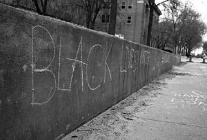 Chalk graffiti from a protest at the University of Iowa in response to the Michael Brown and Eric Garner cases, and on-going issues of racial diversity and tensions.