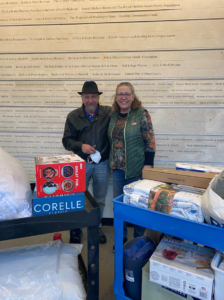 Two people (male and female) standing with carts full of new household goods. 